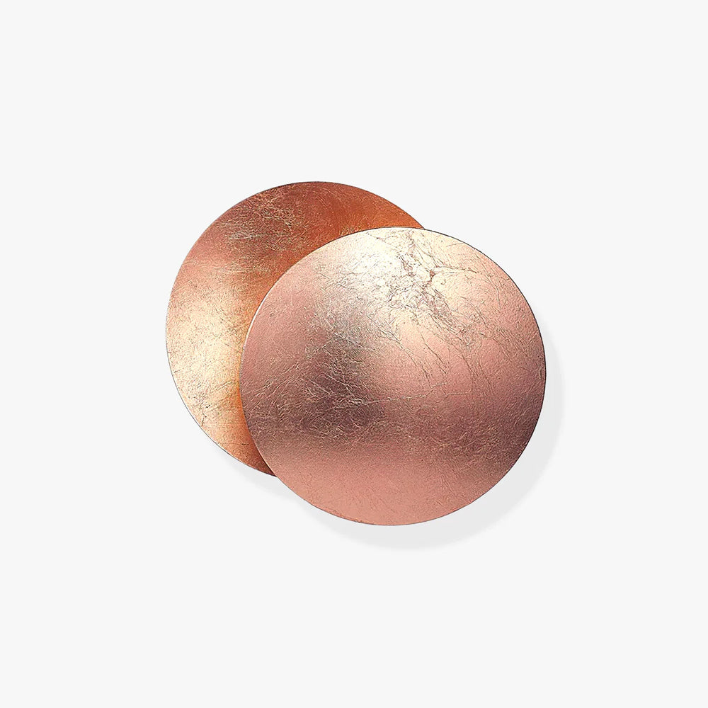 Two overlapping rose-copper discs of this Clérachic wall light on a plain white backdrop, the front disc shown crackled and slightly pink.