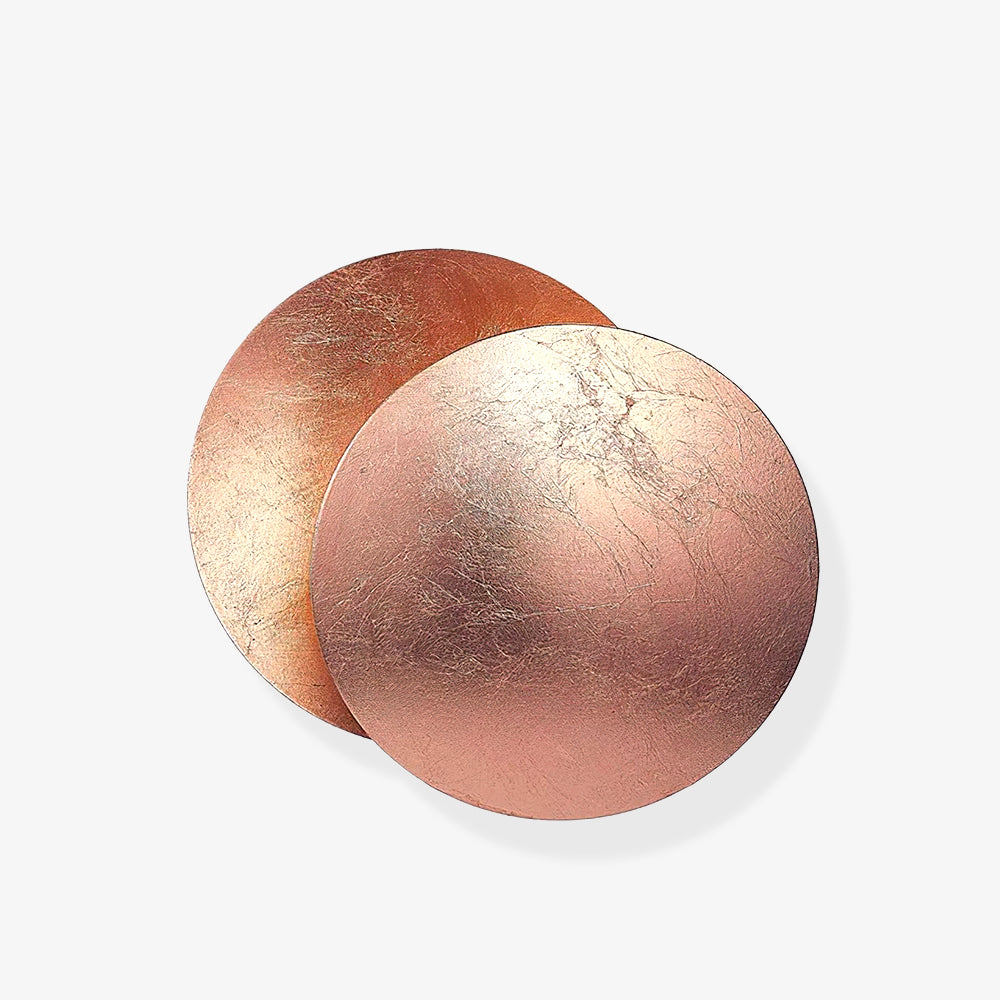Two overlapping rose-copper discs of this Clérachic wall light on a light backdrop, showing the fine crackle of the metal-leaf finish.