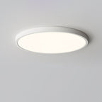 A white-rimmed Clérachic round ceiling light, lit with a soft warm glow, seen from slightly below on a grey ceiling.