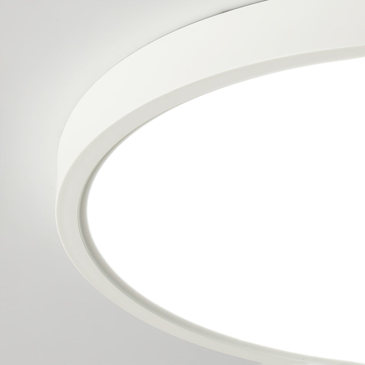 Close view of the white rim and the edge of the glowing acrylic diffuser on this Clérachic ceiling light.