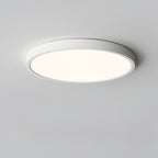 A white Clérachic round ceiling light with a gentle warm-toned glow, shown from slightly below on a pale grey ceiling.