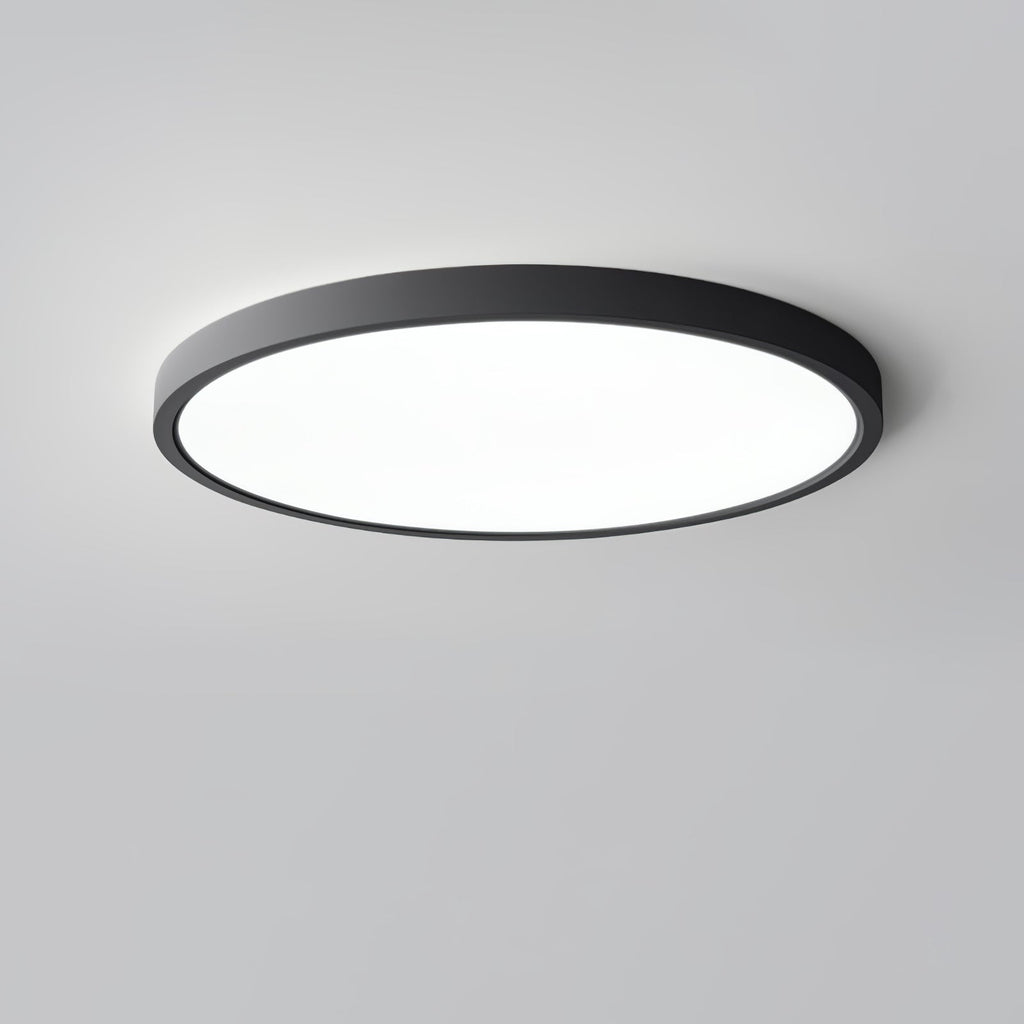A black Clérachic round ceiling light with a large flat white diffuser, photographed from slightly below against a grey backdrop.