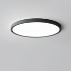 A black Clérachic round ceiling light with a large flat white diffuser, photographed from slightly below against a grey backdrop.