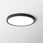 A black-rimmed Clérachic round ceiling light with a bright diffuser, centred on a light grey ceiling.