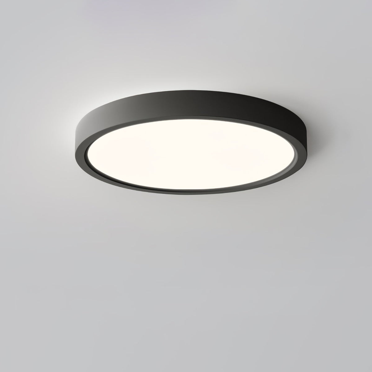 A black Clérachic round ceiling light with a warm glow, viewed from a low angle against a soft grey-lilac ceiling.