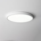 Cool white light from a white Clérachic round ceiling light with a thin white edge, on a pale grey ceiling.