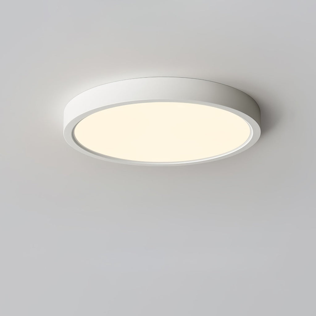 Warm golden glow from a white Clérachic round ceiling light, shown from below on a light grey ceiling.