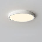 Warm golden glow from a white Clérachic round ceiling light, shown from below on a light grey ceiling.