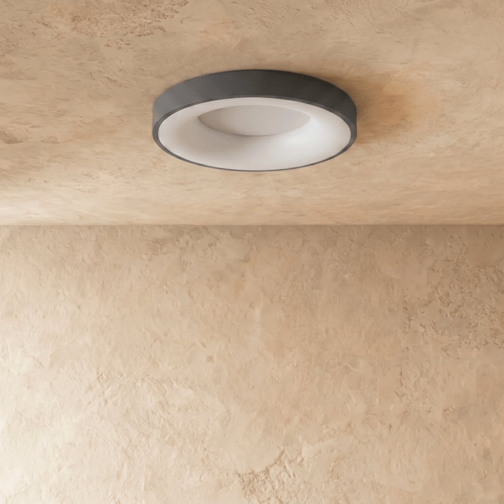 Clérachic grey round ceiling light switched off, showing its white diffuser and slim grey rim on limewash plaster.