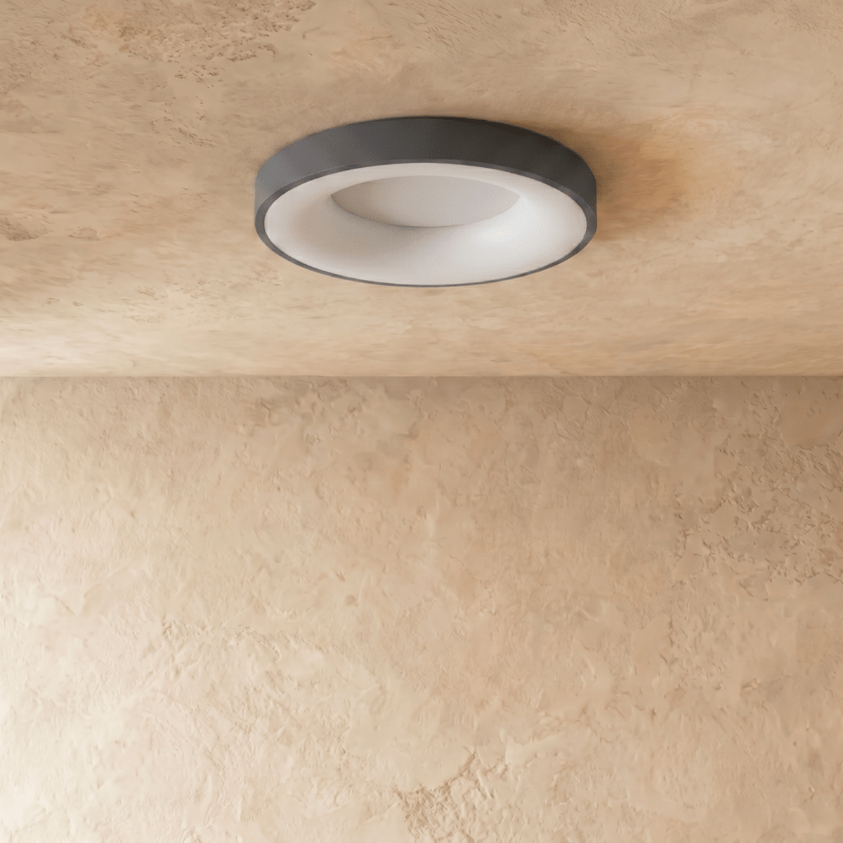 Clérachic grey round ceiling light switched off, showing its white diffuser and slim grey rim on limewash plaster.