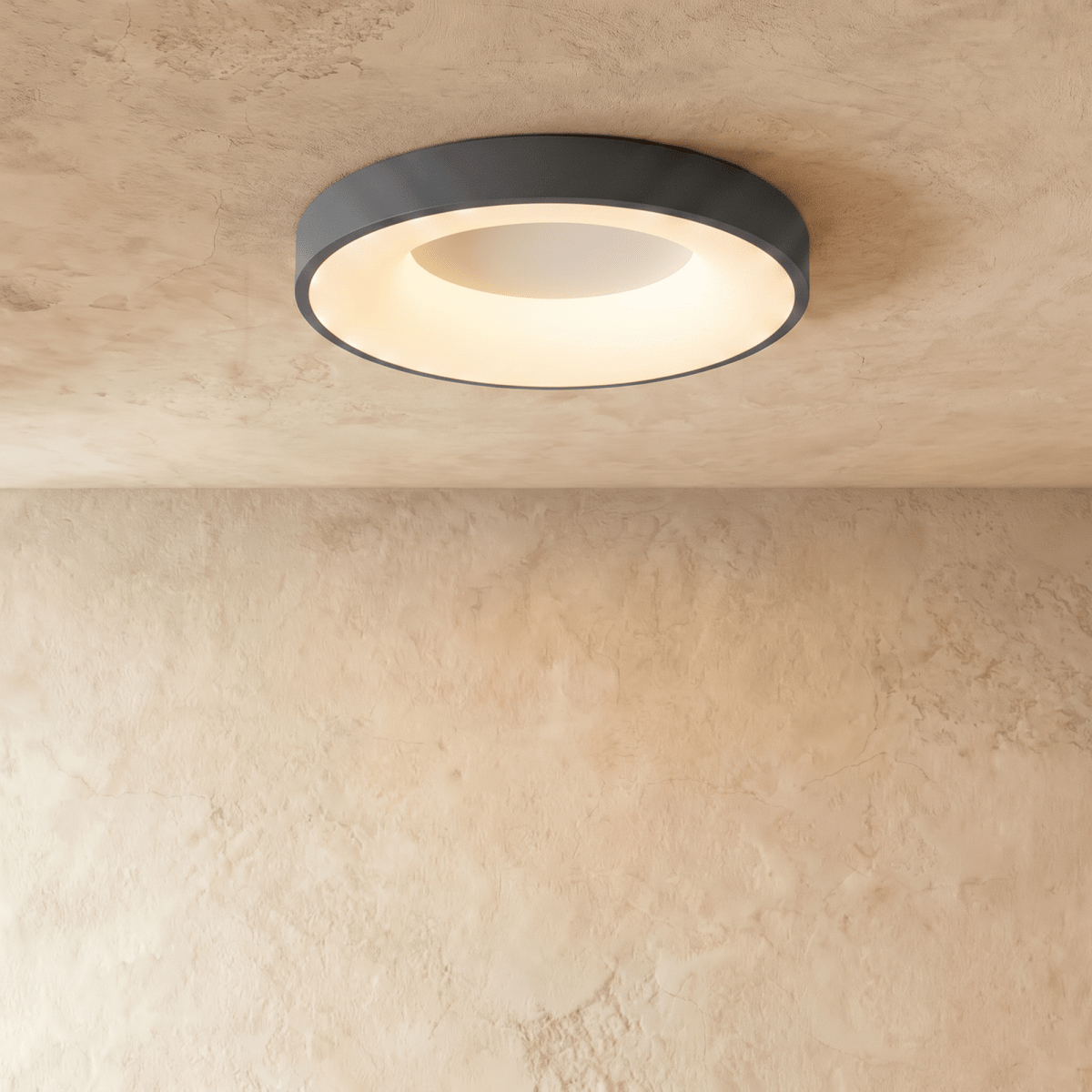 Clérachic larger grey flat ceiling light with a glowing ring around a white centre disc, on a limewash ceiling.