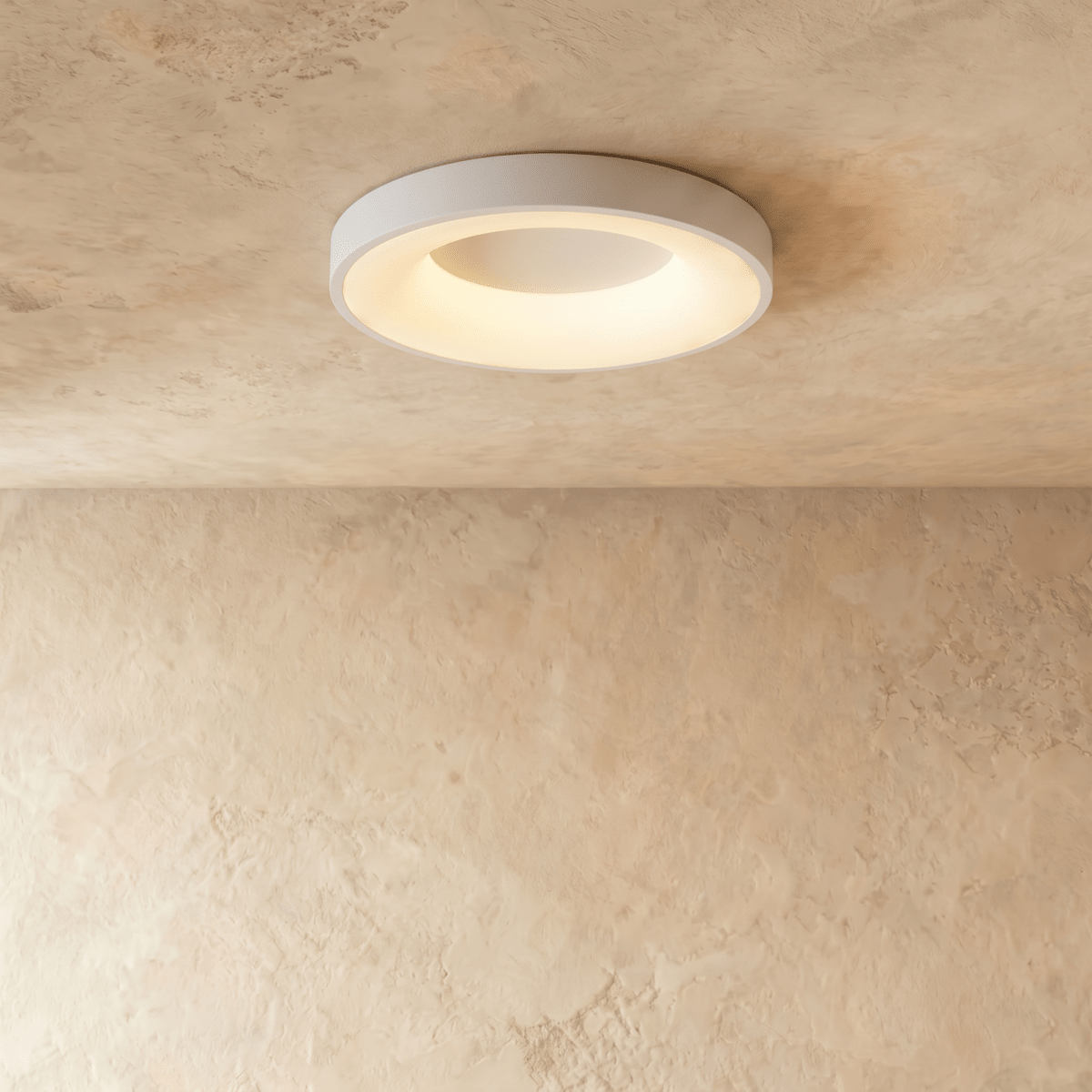 Clérachic white round ceiling light with a glowing inner ring, mounted flush on a textured limewash ceiling.