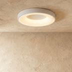 Clérachic largest white round ceiling light with a warm glowing ring, shown flush against a limewash ceiling.