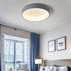 Clérachic grey round ceiling light lit warm white above a child-friendly bedroom with blue curtains and framed prints.