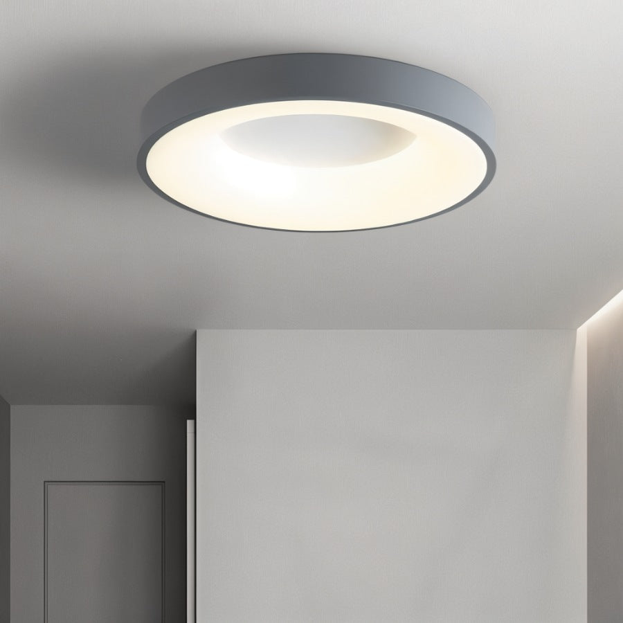 Clérachic grey round ceiling light glowing warm white in a pale grey hallway beside a plain wall and door.