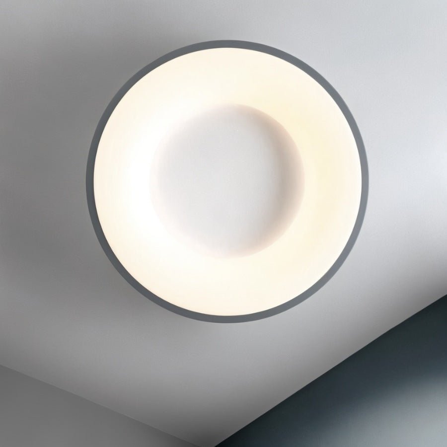 Clérachic round ceiling light seen from below, with a thin grey rim around a glowing ring and a white centre disc.