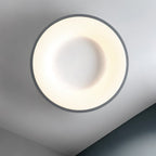 Clérachic round ceiling light seen from below, with a thin grey rim around a glowing ring and a white centre disc.