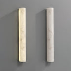 Two Clérachic alabaster sconces side by side on a grey wall, the left one lit and the right one switched off.