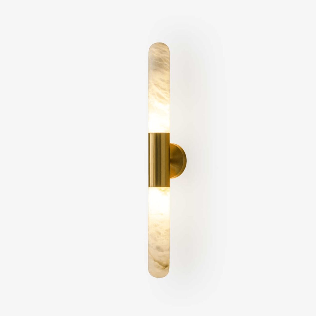 This Clérachic wall light on a plain white backdrop, with an alabaster tube above and below a brass-coloured centre band and round wall plate.