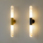 Gold-and-white and black-and-white versions of this Clérachic wall light side by side on a grey-green wall, both lit.
