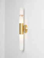 Gold-and-white Clérachic wall light cut out against a pale grey wall, with the brass band and round plate seen from a slight angle.