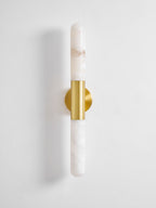 Front view of an unlit Clérachic wall light with white veined alabaster and a brass band, on a plain light wall.