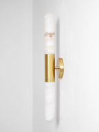 Side-on view of this Clérachic gold-and-white wall light, showing how far the brass plate holds the alabaster tubes from the wall.