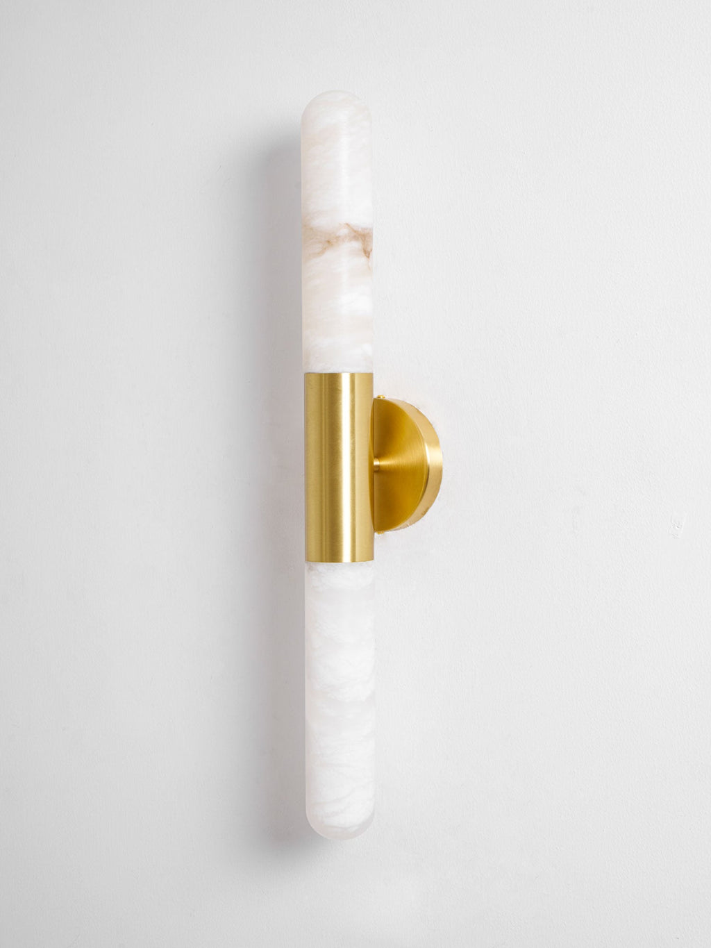 Straight-on view of a Clérachic gold-and-white wall light, with a long white alabaster tube above and below the brass band.