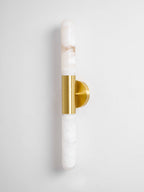 Straight-on view of a Clérachic gold-and-white wall light, with a long white alabaster tube above and below the brass band.