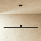 Straight-on view of the Clérachic linear bar pendant light, its slim aluminium body lit warm white beneath a plain plastered ceiling.
