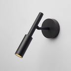 Angled view of a black Clérachic wall light with a slim tube head swivelled outward from its round backplate.