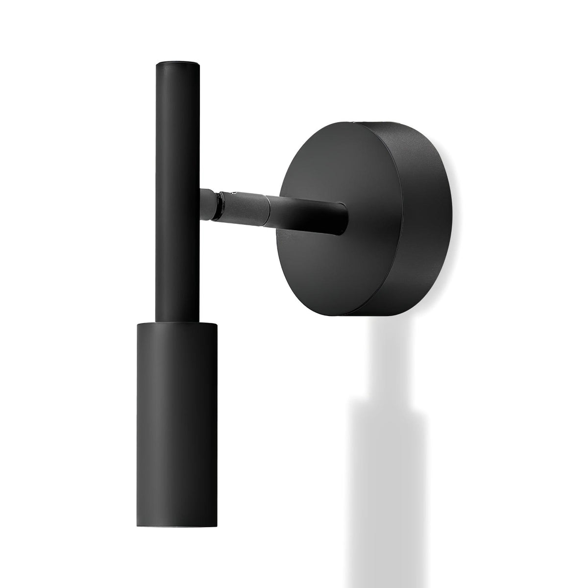 A black Clérachic wall light with a round backplate and a slim vertical tube head, with a faint reflection below it.