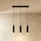 Clérachic three-head pendant light, black gold-banded cylinders hung in a row from a slim rectangular black canopy.
