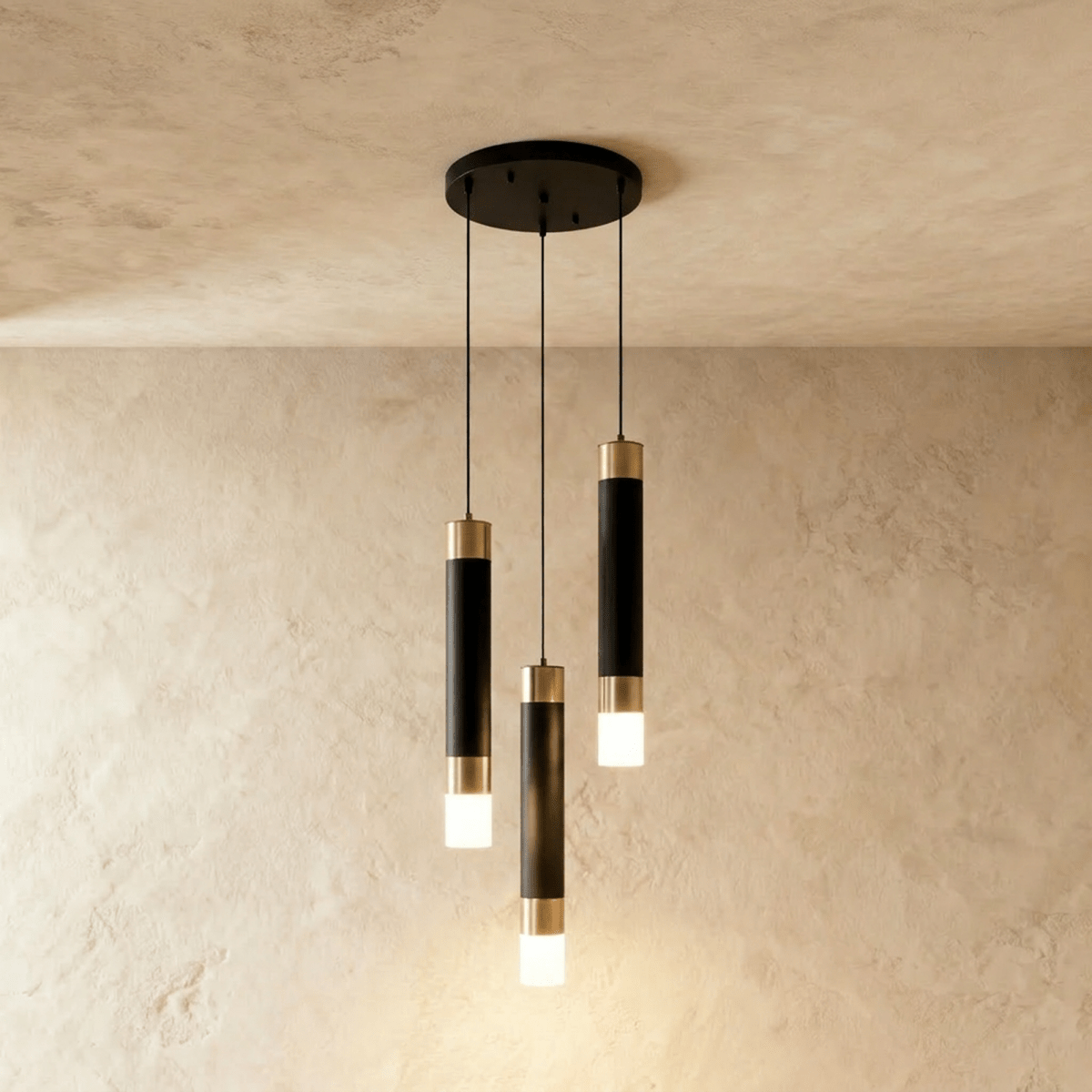 Clérachic three-head pendant light, black gold-banded cylinders at staggered heights from a round black canopy.