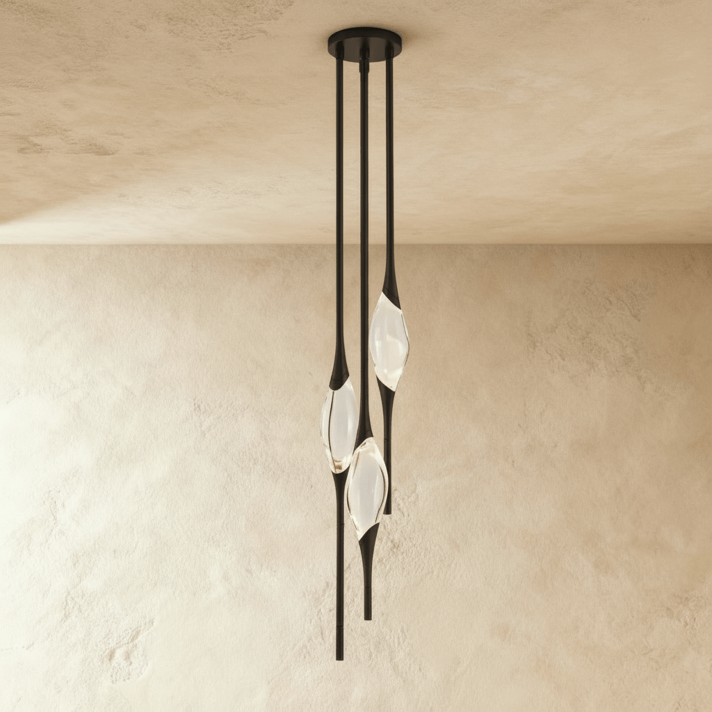 Clérachic three-head pendant in black with slim rods and clear glass teardrops, hung from a round black canopy on a plaster wall.