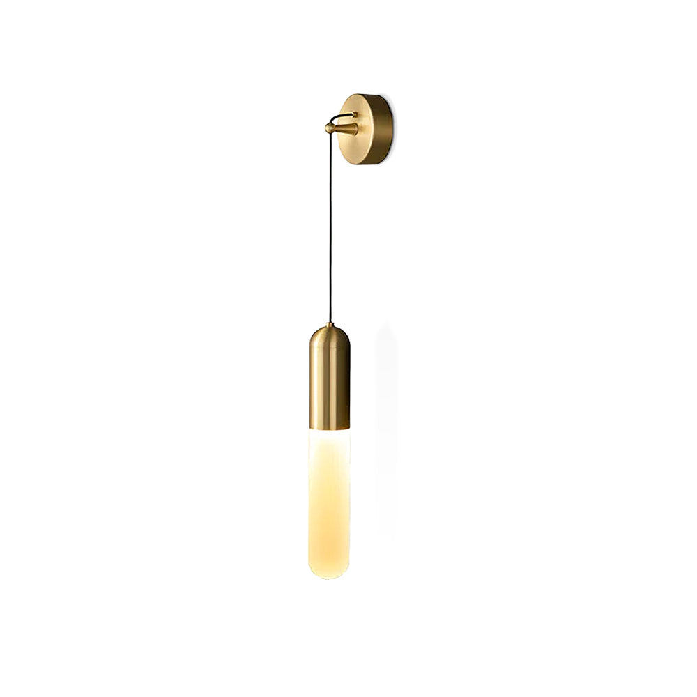 Cut-out view of this brass Clérachic wall light on white, its warm lit cylinder shade hanging below a brass cap on a thin cord.