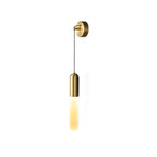 Cut-out view of this brass Clérachic wall light on white, its warm lit cylinder shade hanging below a brass cap on a thin cord.