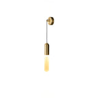 Small cut-out view of the brass Clérachic wall light on white, the slim cylinder shade lit in a warm amber tone.