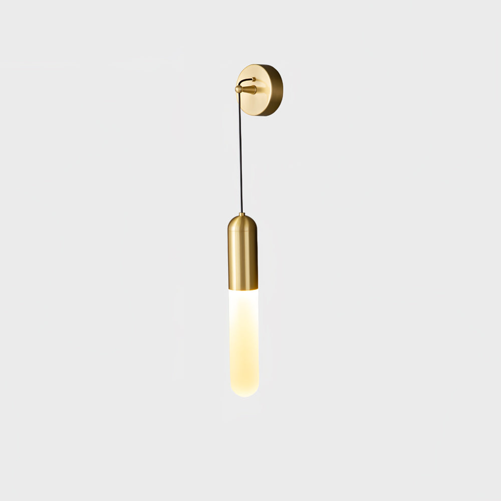 Brass Clérachic wall light on a pale grey backdrop, a round brass plate and cap above a softly lit slim cylinder shade.