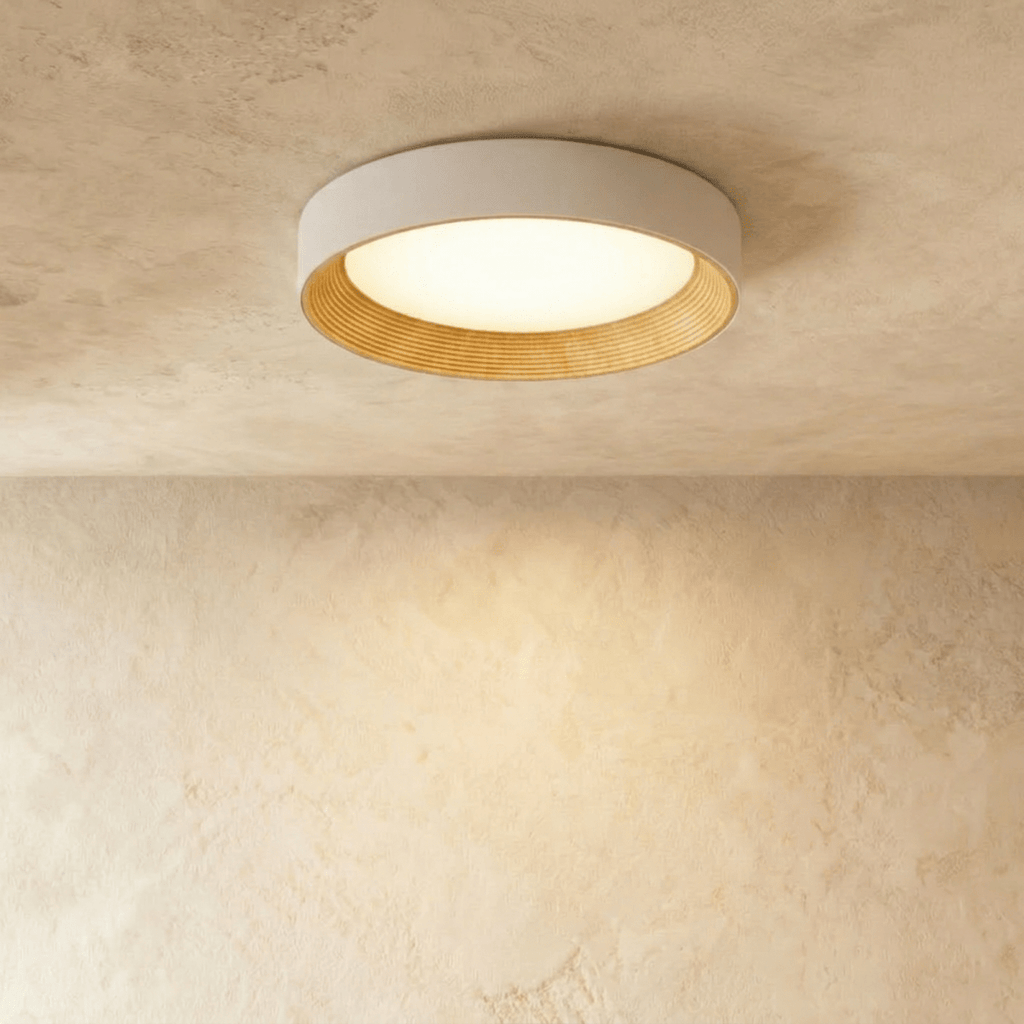 Clérachic mid-size round flush ceiling light, pale rim, ribbed light wood inner ring and a lit diffuser on plaster.