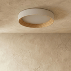 Clérachic large round flush ceiling light switched off, showing its pale rim, matte diffuser and ribbed light wood ring.