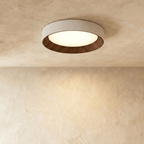 Clérachic mid-size round flush ceiling light, pale rim, dark ribbed walnut-tone ring and a glowing diffuser on plaster.