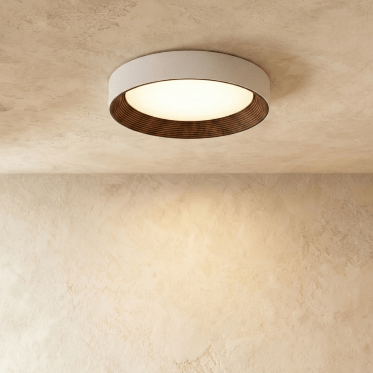 Clérachic mid-size round flush ceiling light, pale rim, dark ribbed walnut-tone ring and a glowing diffuser on plaster.
