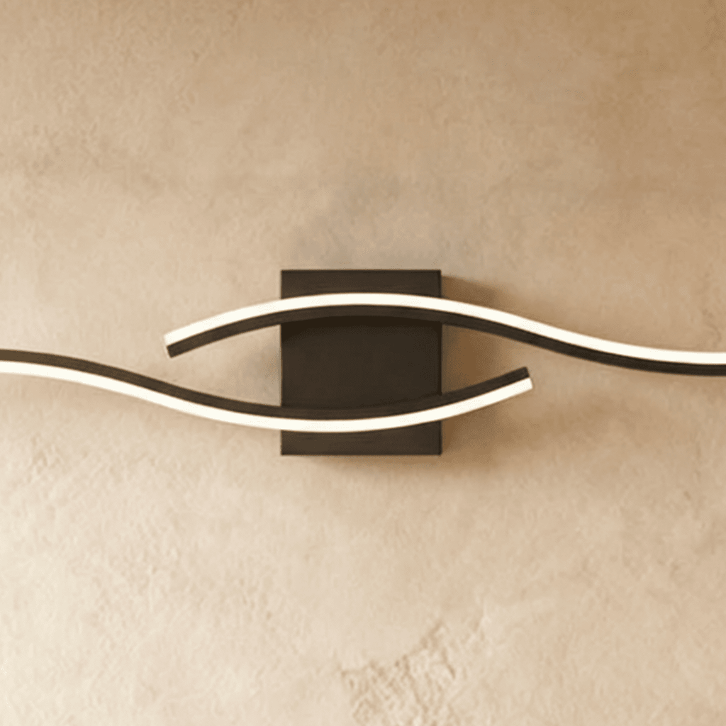 Close view of the Clérachic black wall lamp, showing the lit diffuser strips curving past a square matte backplate.