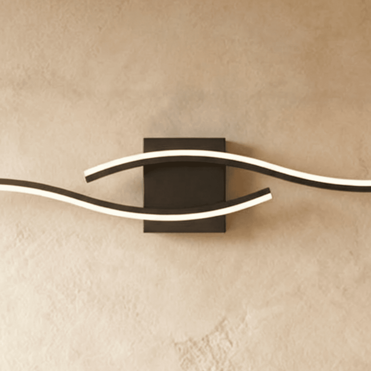 Close view of the Clérachic black wall lamp, showing the lit diffuser strips curving past a square matte backplate.