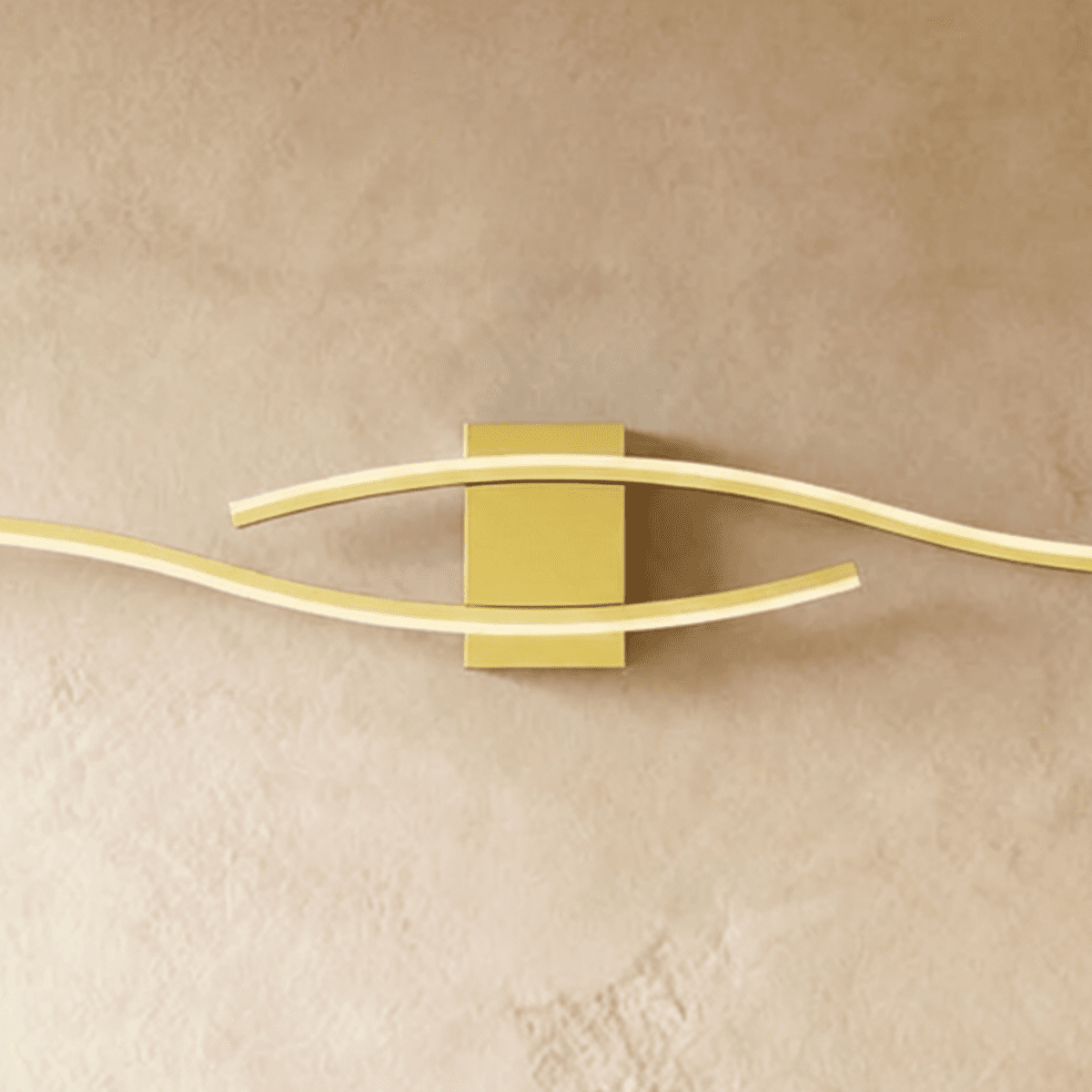 Close view of the Clérachic gold wall lamp's rectangular backplate and two softly glowing wavy diffuser bars.