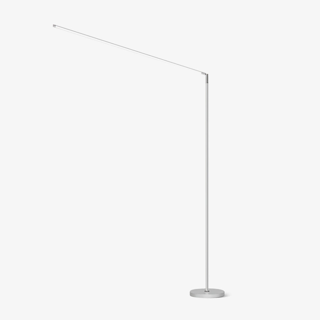 White version of this Clérachic slim floor lamp, with a thin upright pole, a long angled light arm and a round base, on a plain white backdrop.