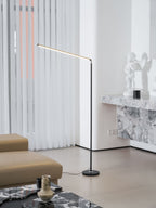 This Clérachic floor lamp stands beside a marble console, with its light bar lit, in front of sheer curtains and a tan sofa.