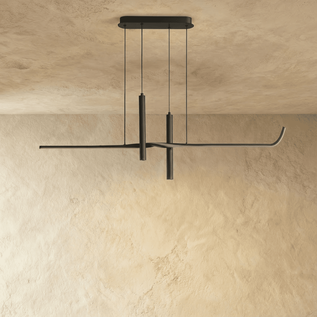 Clérachic slim black linear pendant with two suspended spotlight tubes, hung on thin wires against a limewash wall.