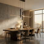 Clérachic black linear pendant above a long timber dining table in a bright concrete-walled room with a morning city view.